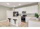 Modern kitchen with white cabinets, stainless steel appliances, and an island at 6943 Cupseed Ln, Harmony, FL 34773