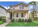 Two-story house with a front porch, landscaping, and a large yard at 6943 Cupseed Ln, Harmony, FL 34773