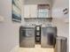 Bright laundry room, featuring modern washer and dryer, stylish tile and white cabinets at 6943 Cupseed Ln, Harmony, FL 34773