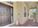 Front entry with dark brown door, welcome mat, and brick flooring at 6943 Cupseed Ln, Harmony, FL 34773