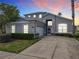 Two-story house exterior, featuring a gray facade and a well-lit driveway at 107 Julliard Blvd, Davenport, FL 33897