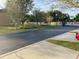Landscaped entrance to a community with paved roads and streetlights at 718 Verona Ave, Davenport, FL 33897