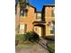 Two-story tan house with a walkway and landscaping at 718 Verona Ave, Davenport, FL 33897