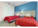 Two twin beds in a bedroom featuring a white closet and blue accent wall at 3148 Pequod Pl, Kissimmee, FL 34746