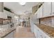 Kitchen boasts granite countertops, white cabinets, and tile floors at 384 Grand Canal Dr, Poinciana, FL 34759