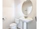 Clean bathroom with pedestal sink, toilet, and an oval mirror at 1134 Tapestry Dr, Celebration, FL 34747