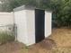 White storage shed with black door in backyard at 1204 Lake Elbert Se Dr, Winter Haven, FL 33880