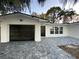 Updated home exterior boasts a modern black garage door and a gray paver driveway at 1204 Lake Elbert Se Dr, Winter Haven, FL 33880