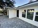 Modern front entrance with black door and gray paver walkway at 1204 Lake Elbert Se Dr, Winter Haven, FL 33880
