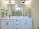 Modern bathroom with double vanity, large mirror, and a walk-in shower at 1690 Houston St, Kissimmee, FL 34743