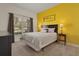Cozy bedroom with a queen-size bed and yellow accent wall at 3060 Gatsby St, Kissimmee, FL 34746