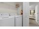 Bright laundry room with washer, dryer, and extra shelving at 3060 Gatsby St, Kissimmee, FL 34746