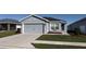 Gray house with a two-car garage and well-manicured lawn at 305 Cascara Ln, Auburndale, FL 33823
