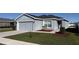 Gray house with a two-car garage and landscaping at 305 Cascara Ln, Auburndale, FL 33823