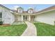 Elegant entryway with stonework, double doors, and a landscaped walkway at 7920 Summer Ridge Pl, Orlando, FL 32819