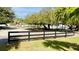 Black wooden fence bordering a large grassy area at 6747 Whispering Pines Rd, Orlando, FL 32824