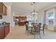 Elegant dining area with glass table and wicker chairs, open to kitchen at 1217 Radiant St, Reunion, FL 34747