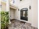 Elegant front entrance with black door and landscaping at 1217 Radiant St, Reunion, FL 34747