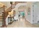 Elegant two-story entryway with tile flooring, a wooden staircase, and a charming sitting area at 1217 Radiant St, Reunion, FL 34747