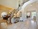Bright and spacious entryway, featuring a grand staircase and views into the living and dining areas at 1217 Radiant St, Reunion, FL 34747