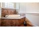 Soaking tub with tile surround in a well-lit bathroom at 1217 Radiant St, Reunion, FL 34747