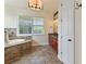 Spa-like bathroom with soaking tub, granite vanity, and tile floor at 1217 Radiant St, Reunion, FL 34747