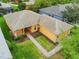 An aerial view of a charming house with a brick pathway and lush green lawn at 153 Marabella Loop, Poinciana, FL 34759