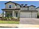Two-story house with a two-car garage and manicured lawn at 8059 Leaf Grove Cir, Orlando, FL 32836