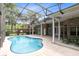 Refreshing kidney-shaped pool with screened enclosure and patio at 840 Coach Lamp Ct, Sanford, FL 32771