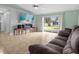 Bright living room with tiled floors, large TV, and sliding doors leading to the backyard at 617 Brockton Dr, Kissimmee, FL 34758