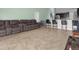 Open living room and kitchen area with tiled floor and a large sectional sofa at 617 Brockton Dr, Kissimmee, FL 34758