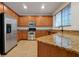 Kitchen with wood cabinets, granite counters, and stainless steel appliances at 10233 Serotina Ct, Orlando, FL 32832