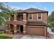 Two story house with brown exterior, two car garage and manicured lawn at 10233 Serotina Ct, Orlando, FL 32832