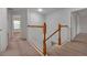 Upstairs hallway with carpet flooring, wooden railing, and access to bedrooms at 10233 Serotina Ct, Orlando, FL 32832