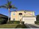 Two-story house with tan exterior, palm tree, and attached garage at 1821 Morning Star Dr, Clermont, FL 34714