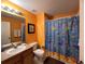 Bathroom with tub shower, wood vanity, and ocean-themed decor at 1821 Morning Star Dr, Clermont, FL 34714