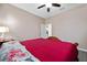 Red bedding and floral pillows in this spacious bedroom at 3260 Marshfield Preserve Way, Kissimmee, FL 34746