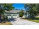 Light green house exterior with 2-car garage and landscaping at 3260 Marshfield Preserve Way, Kissimmee, FL 34746