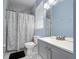 Clean bathroom with shower/tub combo, gray vanity, and marble-tiled floors at 3260 Marshfield Preserve Way, Kissimmee, FL 34746
