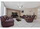 Spacious living room with brown leather furniture and a large TV at 3260 Marshfield Preserve Way, Kissimmee, FL 34746