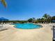 Community pool with lounge chairs and umbrellas at 2732 Oakwater Dr # 101, Kissimmee, FL 34747