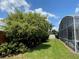 Landscaped backyard with lush greenery and a screened pool area at 7953 Sea Pearl Cir, Kissimmee, FL 34747