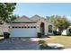 House exterior, featuring a two-car garage and landscaped lawn at 2726 Randal Way, Kissimmee, FL 34743