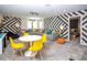 Bright game room with sectional sofa, table and chairs, and bold geometric wall decor at 4577 Target Blvd, Kissimmee, FL 34746