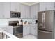 Modern kitchen with stainless steel appliances and gray cabinets at 4577 Target Blvd, Kissimmee, FL 34746