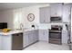 Modern kitchen with gray cabinets, stainless steel appliances, and a kitchen island at 4577 Target Blvd, Kissimmee, FL 34746