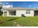 Home's backyard with covered patio, grassy area, and AC unit at 2204 Mac Blvd, Eagle Lake, FL 33839