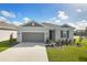 One-story home with gray exterior, landscaping, and two-car garage at 2204 Mac Blvd, Eagle Lake, FL 33839