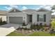 One-story home with gray exterior, landscaping, and two-car garage at 2204 Mac Blvd, Eagle Lake, FL 33839
