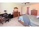 Comfortable bedroom with a desk, dresser, and large bed at 465 Villa Park Rd, Poinciana, FL 34759